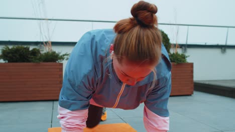 athletic sport girl doing running plank, cross fitness, bodybuilding training routine on rooftop