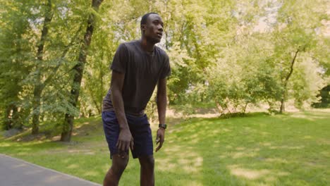 man resting after a run in a park