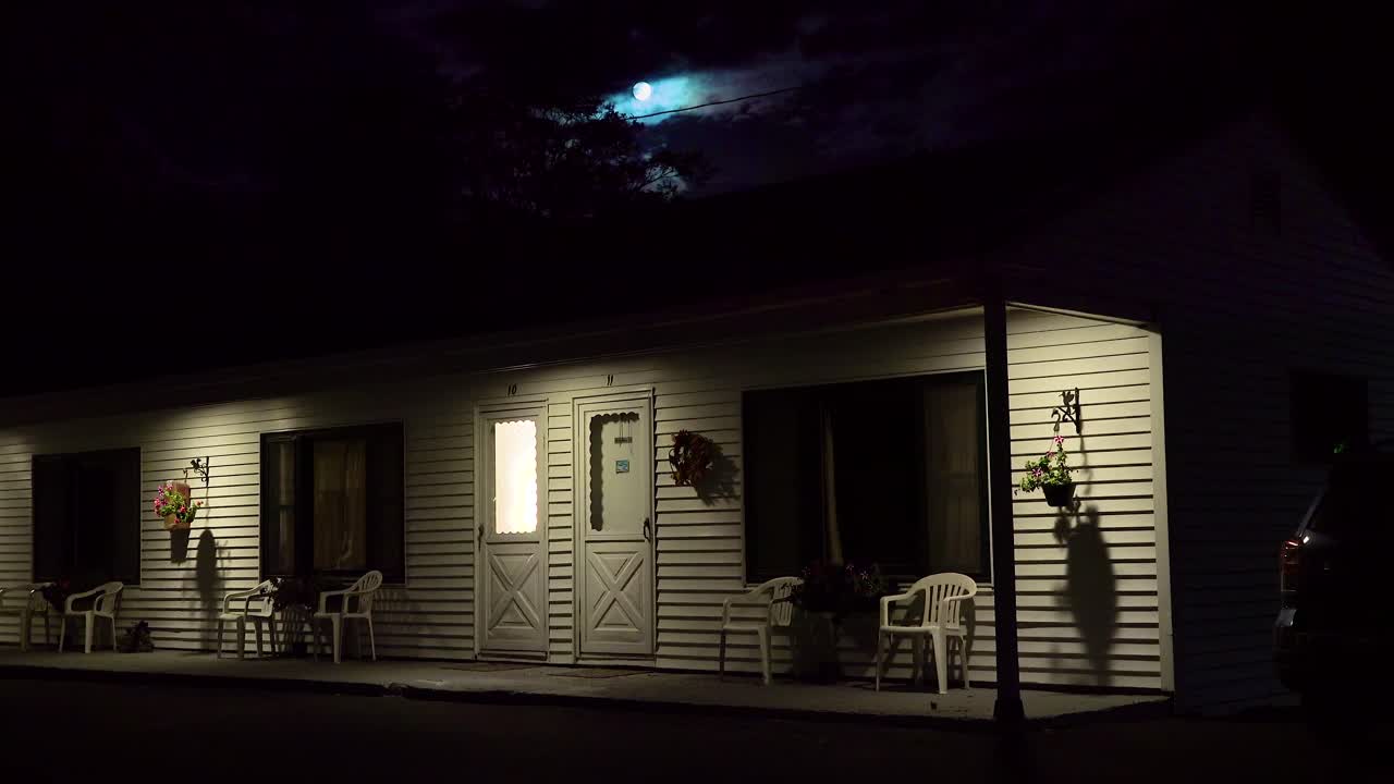Plan d'ensemble d'un motel en bord de route sous une pleine lune, de nuit 4.