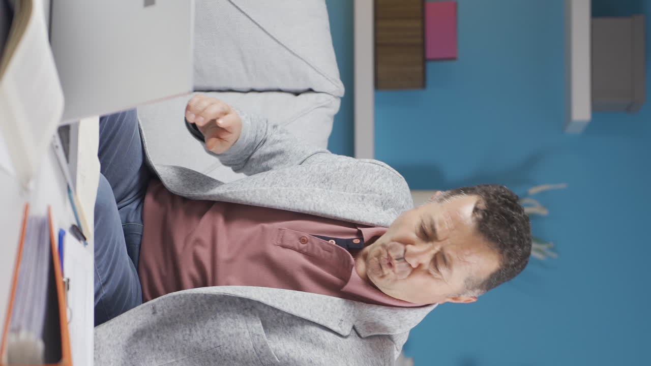 Vertical video of Home office worker old man funny and entertaining.