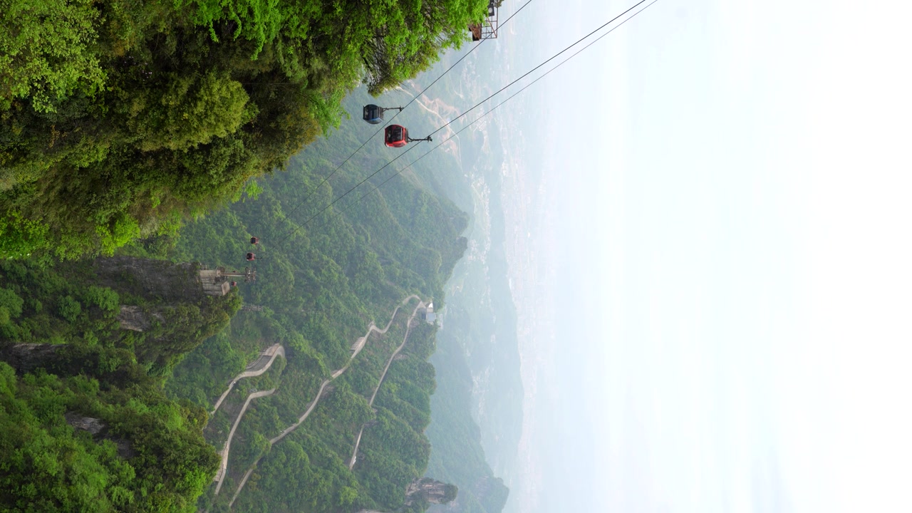 Inquadratura verticale statica dall'alto del Monte Tianmen, della funivia e della vegetazione lussureggiante a Zhangjiajie, Cina