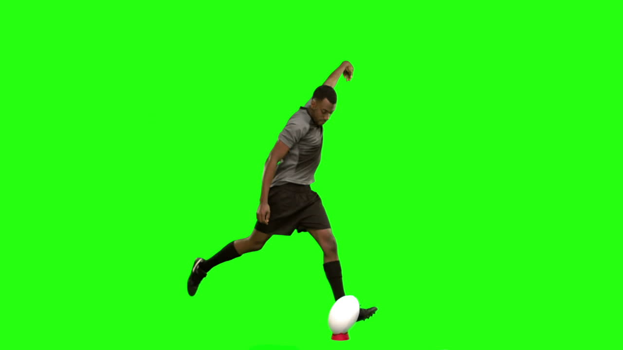 Serious rugby player kicking ball