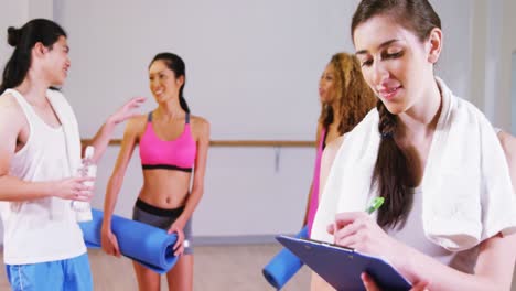 female trainer writing on clipboard