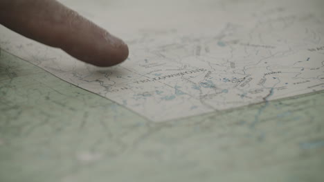 un dedo índice de explorador masculino apuntando al parque nacional de yellowstone en un mapa dentro de su casa en chester, idaho, ee.uu.