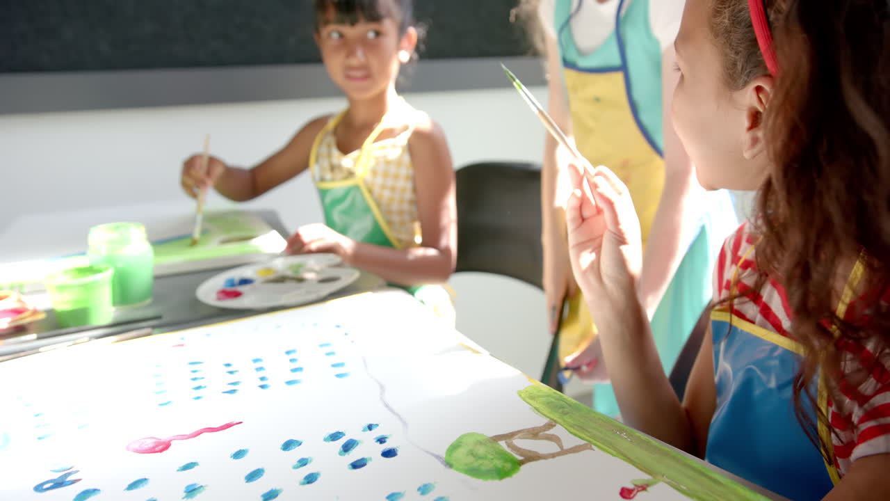In school, children painting on large paper, enjoying creative art activity