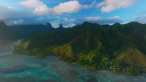 golden hour sunset cooks opunohu bay moorea island french polynesia aerial drone clouds covering mount mauaroa tohivea rotui clouds sailboats lagoon coral reef waves pacific ocean circle right