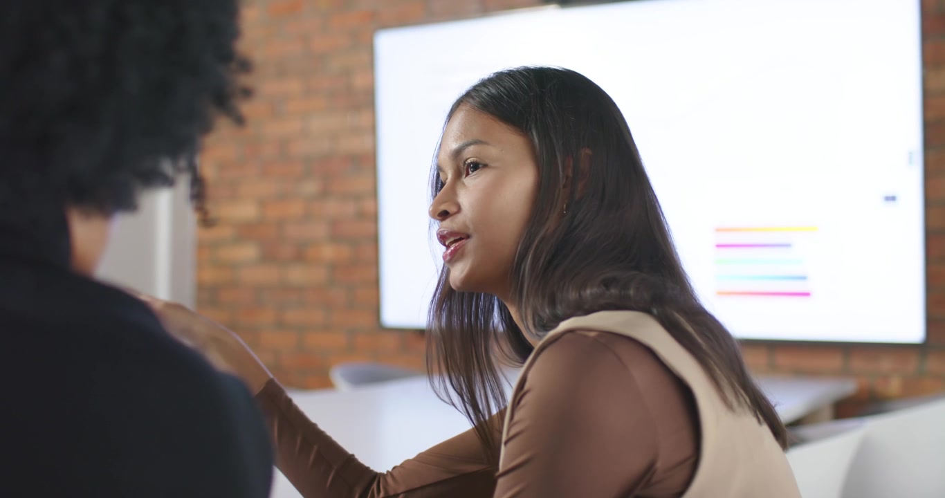 African American team office screen with colored bars sparking talk, woman gesturing and listening