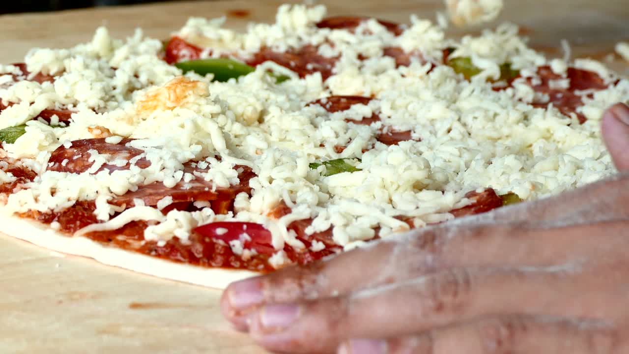 4K footage, close up hand chef putting cheese topping on his pizza base