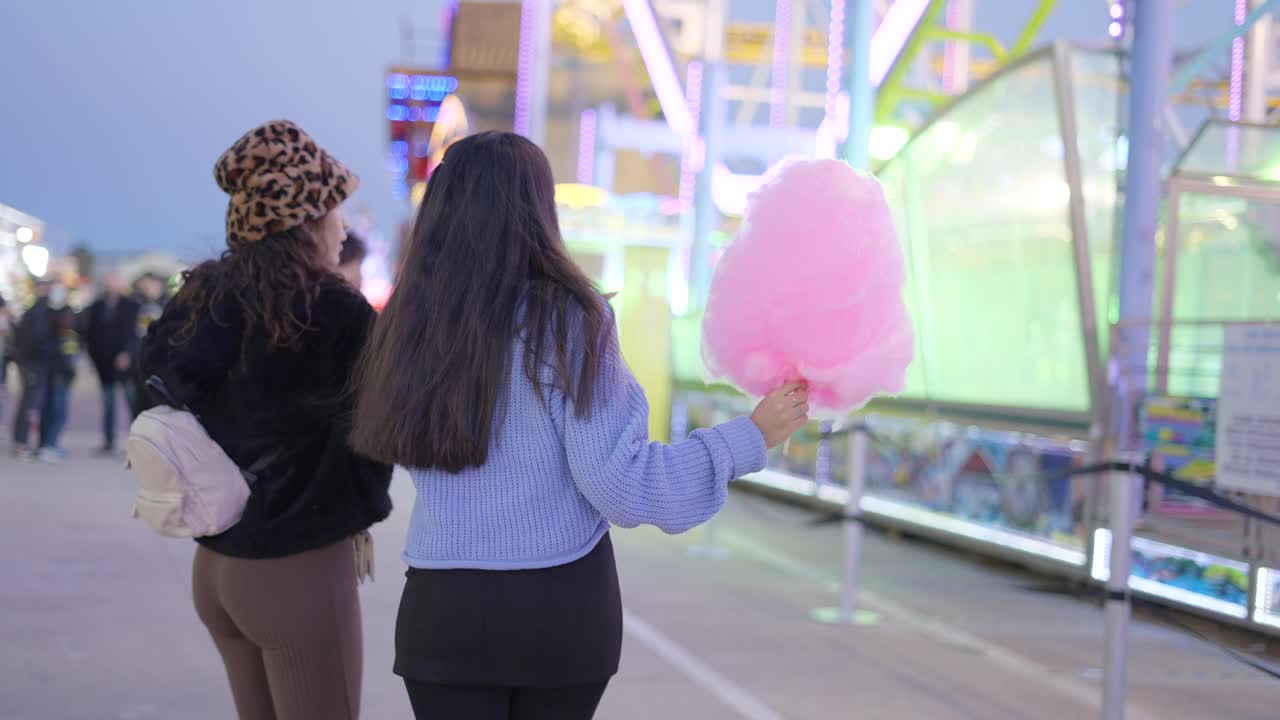 Two Girls Enjoying Cotton Candy at a Fair