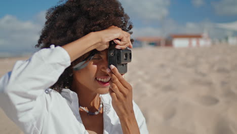 chica feliz tomando una foto en la playa de arena retrato. mujer de cabello negro vertical