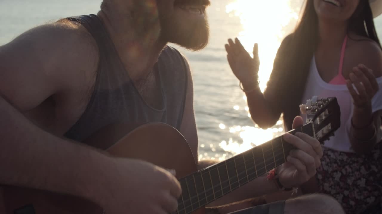 joven tocando la guitarra en la playa