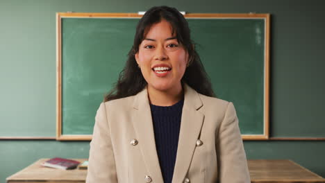 close up shot of female teacher in classroom standing in front of board teaching lesson