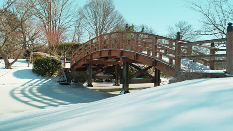 slow pan left shot of quiet snow covered bridge on sunny day