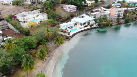 lance aux epines beach with clear waters and tropical houses, aerial view