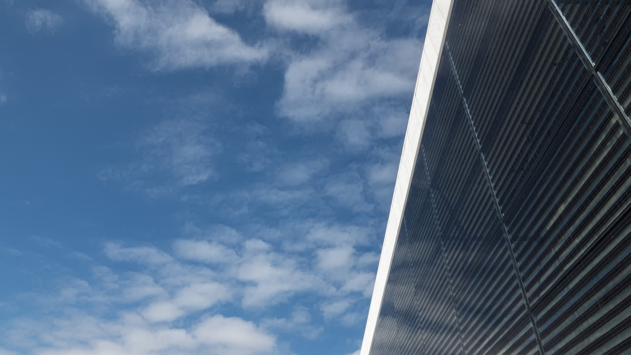 Timelapse, Clouds in Sky Pass Above Reflective Glass of Oslo Opera House