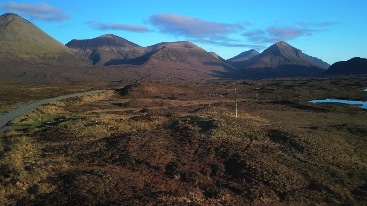 Rapido sorvolo su un paesaggio montano invernale verso le montagne Red Cuillin sull'Isola di Skye, Scozia