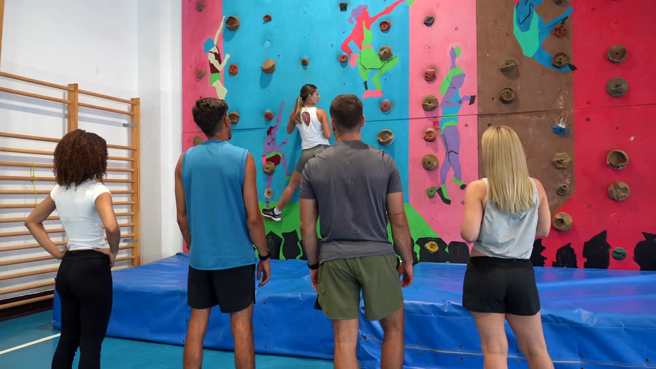 Grupo de pessoas em uma parede de escalada indoor