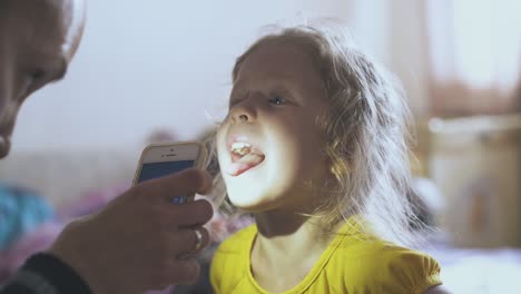 el pediatra examina el dolor de garganta de la niña en la habitación