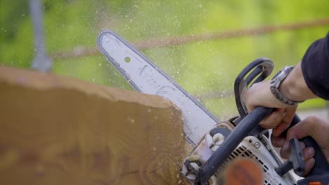 movimiento lento de la motosierra eléctrica cortando tablero de madera, volando polvo de madera en el aire