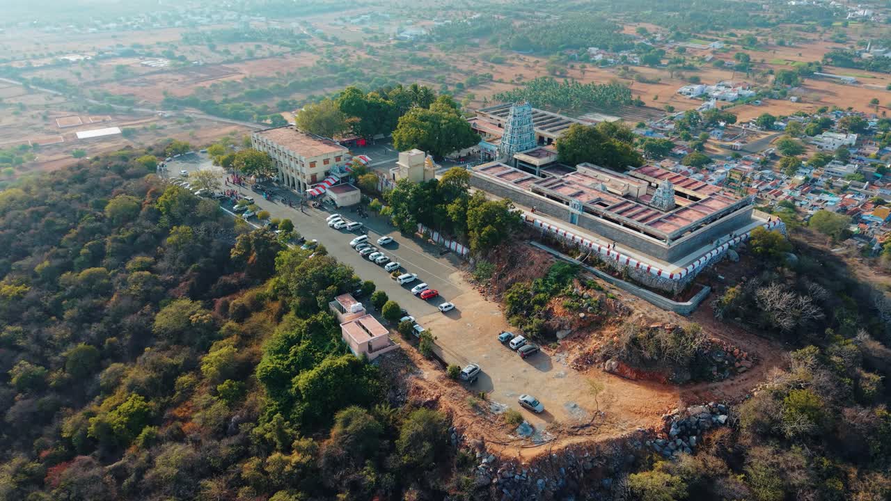 Magnifica vista aerea del tempio di Sivanmalai che si erge sulla cima di una montagna con un villaggio che si estende sulle sue pendici, catturando l'architettura divina, il patrimonio culturale e i paesaggi scenici del Tamil Nadu
