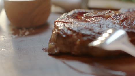 juicy steak is being cut on a board