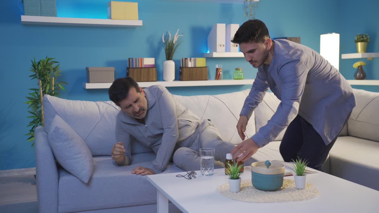 Adult son giving his father's medicine.