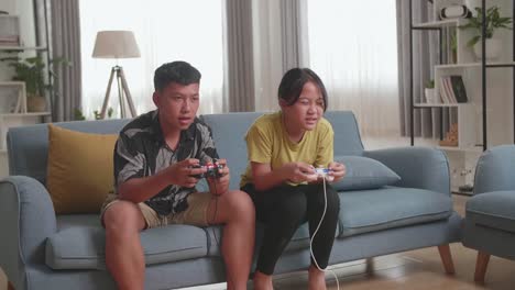asian children with joystick game playing video games and disappointed