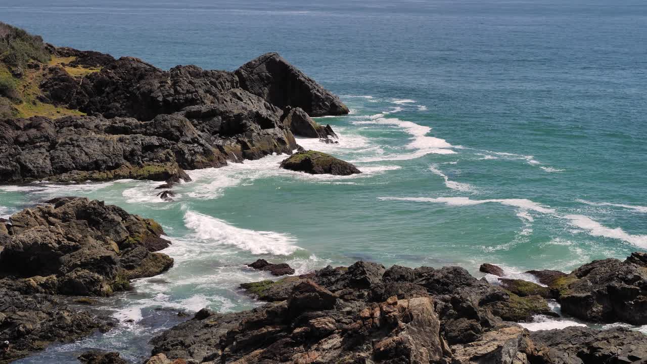 View of the rocks and ocean looking North from Tacking Point Lighthouse, Port Macquarie on a sunny day.