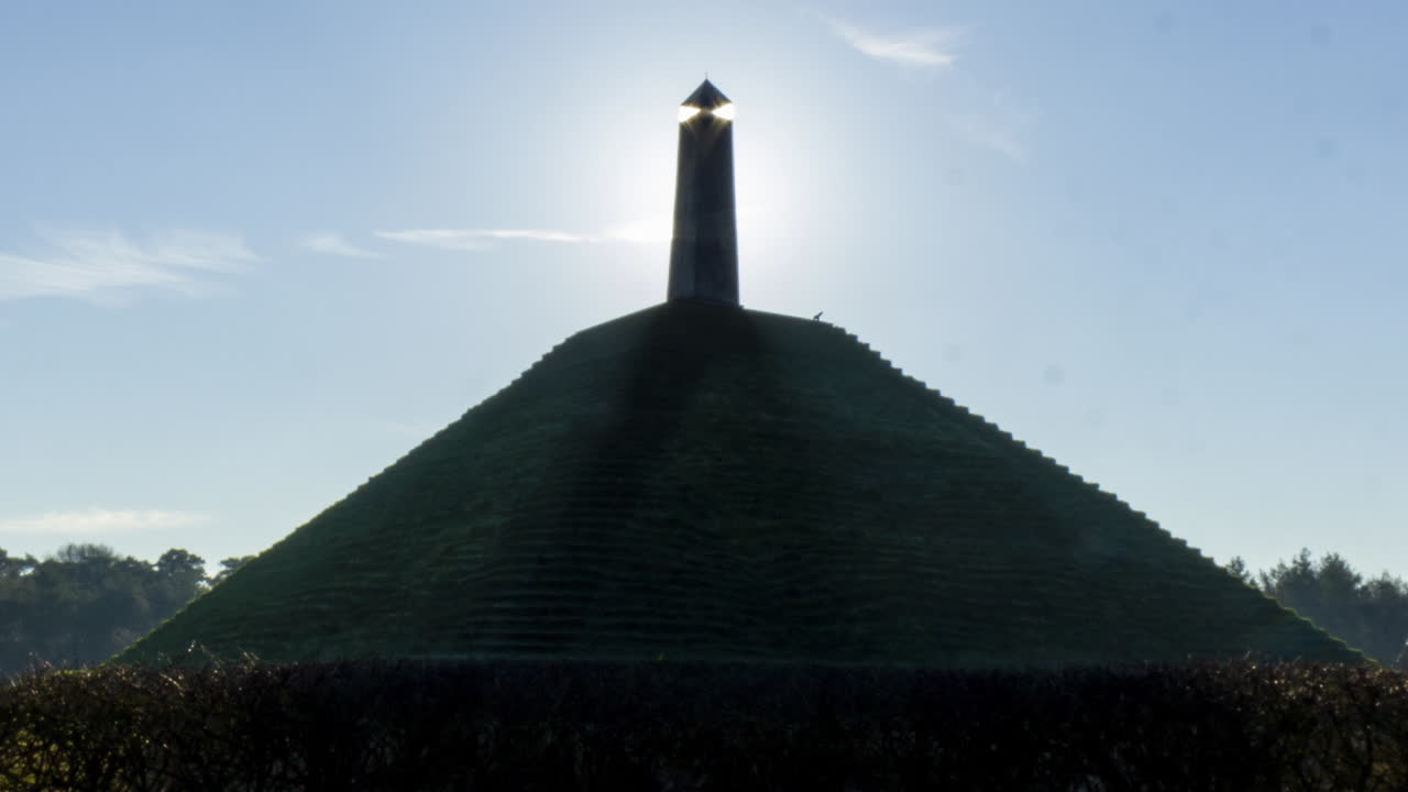 Zoom in - Time lapse of sun appearing behind obelisk on Austerlitz Pyramid. The Piramide van Austerlitz is a monument built in 1804 as a tribute to Napoleon Bonaparte.