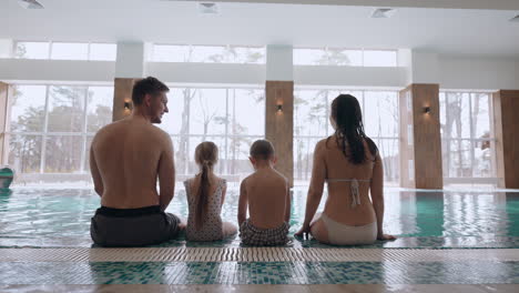 Fin-De-Semana-Tranquilo-En-El-Centro-De-Bienestar-Familiar-Madre-Padre-Hijo-E-Hija-Están-Sentados-En-El-Borde-De-La-Piscina