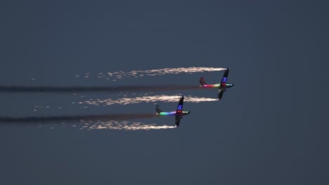 tandem pyrotechnical aircraft doing tight maneuvers together whilst letting off fireworks