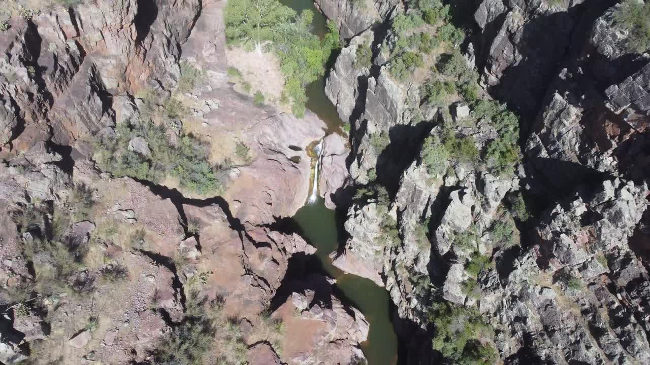 video de un dron de arizona de una toma de arriba hacia abajo del arroyo de la cascada con agua y cactus cerca de un cañón de caja