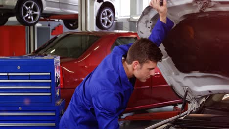 mecánico que hace el mantenimiento de un motor de coche
