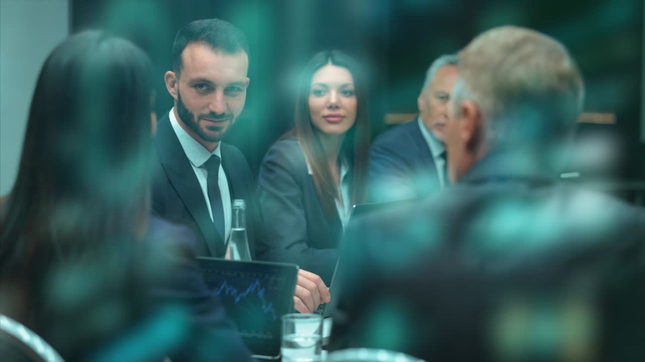 Le persone sedute al tavolo che parlano durante la riunione di lavoro