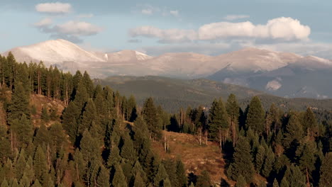 la primera nieve en los picos de las montañas monte cielo azul evans drone aéreo cinematográfico revelar disparado desde siempre verde colorado idaho manantiales denver amanecer primera luz impresionante medio paralaje círculo dramático a la derecha