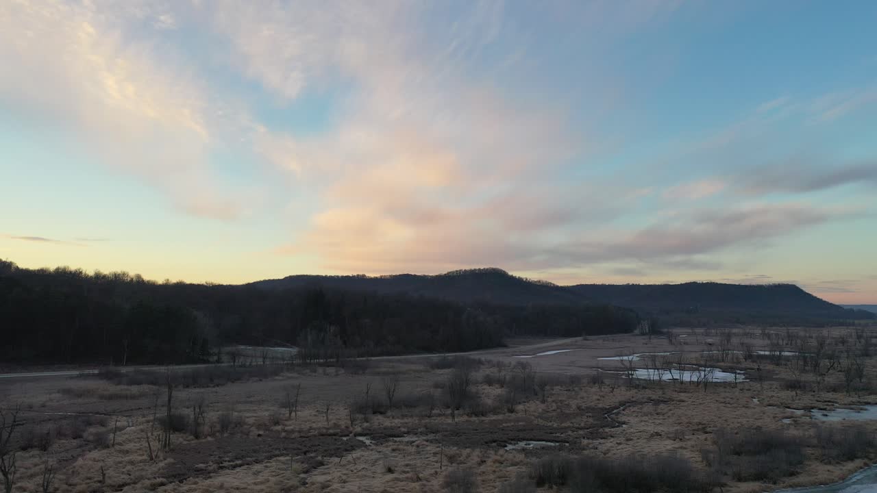 습지와 숲 위의 해가 뜨고 해가 지는 겨울 풍경