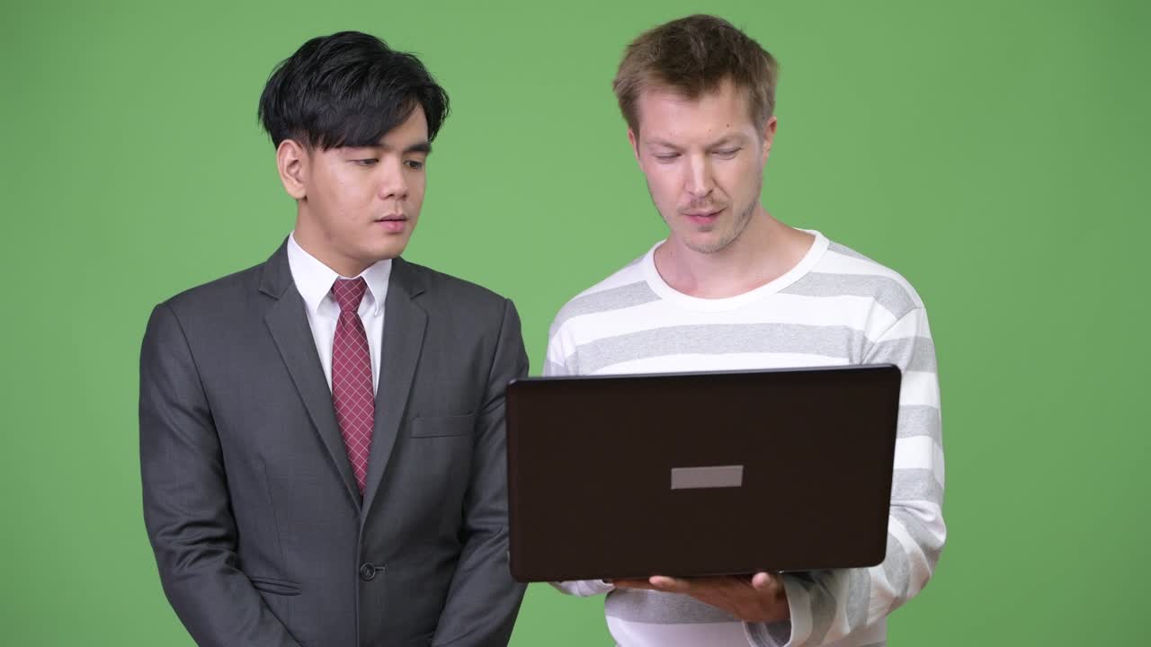 젊은 잘생긴 아시아 사업가와 젊은 스칸디나비아 사업가가 함께 일하고 있습니다.