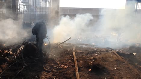 worker, cutting the metal scrap with gas cutter at scrapyard