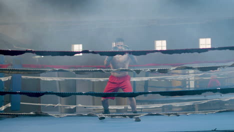 Strong-male-athlete-doing-shadow-fight-in-boxing-gym