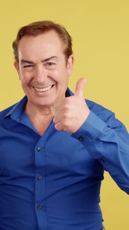 happy man giving thumbs up on yellow background