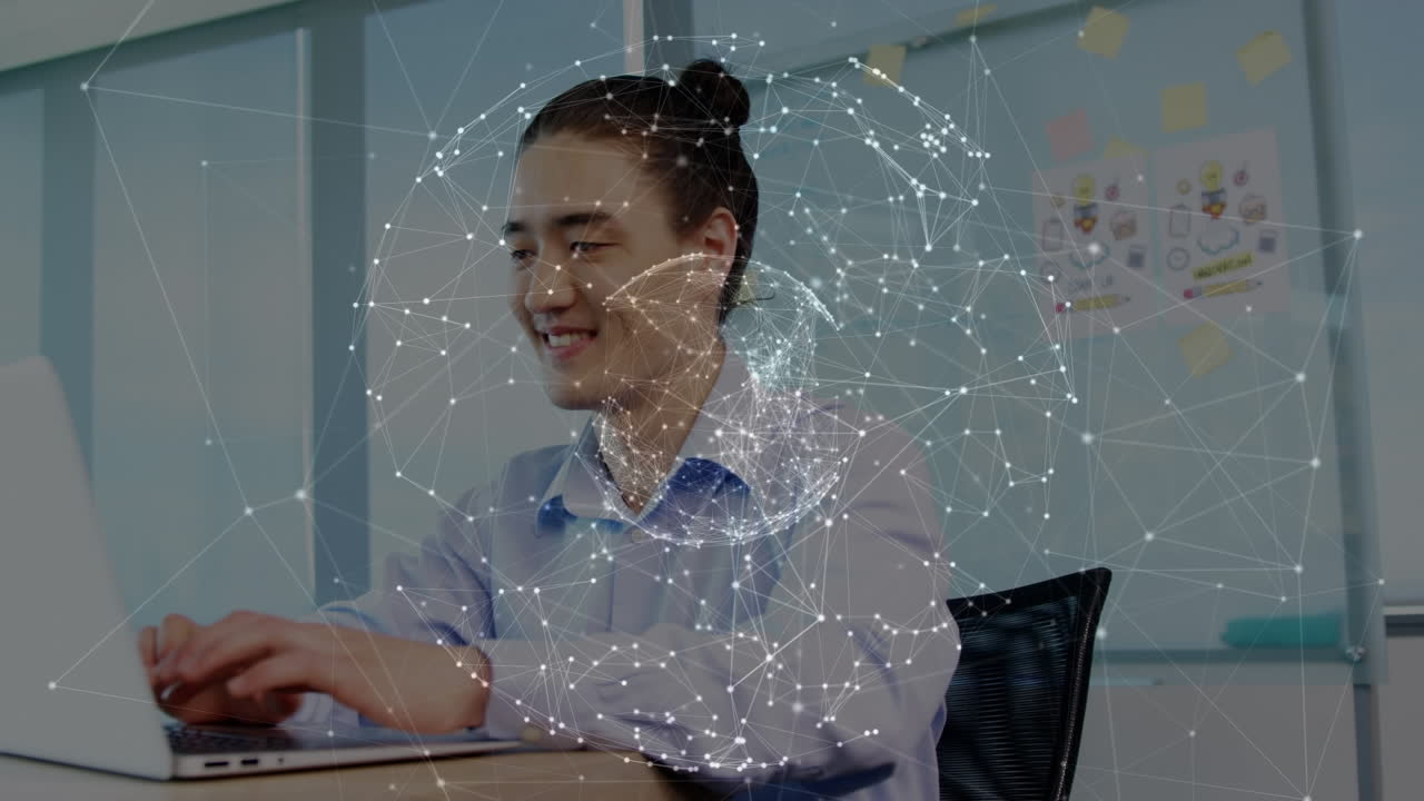 animación de conexiones y globo sobre feliz hombre asiático trabajando en computadora portátil en la oficina