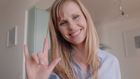 hermosa mujer rubia teniendo video chat usando lenguaje de señas en el teléfono inteligente en casa hablando compartiendo estilo de vida disfrutando de la comunicación en línea en pantalla horizontal