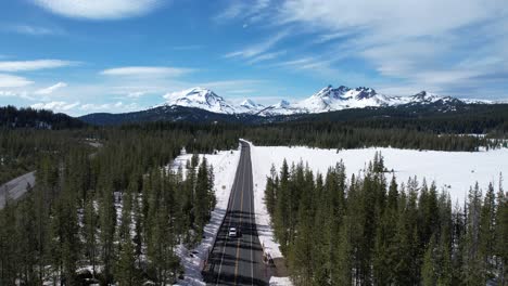 Car-driving-down-highway-away-from-the-snow-capped-Cascade-Mountains