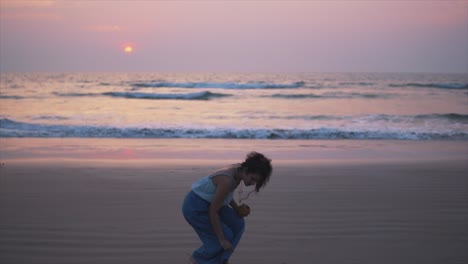 woman picking a rock at the beach