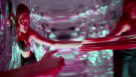 female dancer moving among distorted reflections in neon lit studio