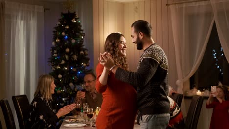 año nuevo. familia en la cena de vacaciones. atmósfera agradable. pareja joven bailando.