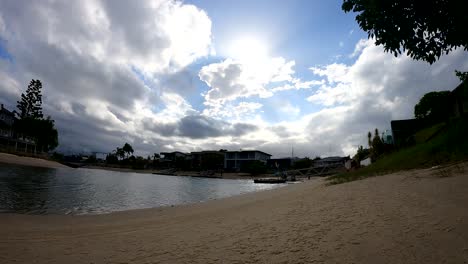 nubes moviéndose sobre una tranquila playa junto al río