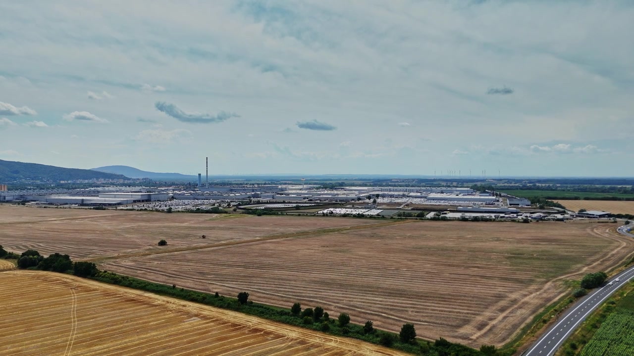 Uitzicht op een industriegebied nabij landbouwgrond en een snelweg in een landelijke omgeving