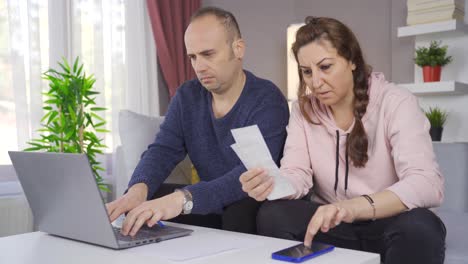 La-Pareja-Hace-Cálculos-En-Casa-Con-Una-Calculadora-Y-Mira-Los-Billetes.