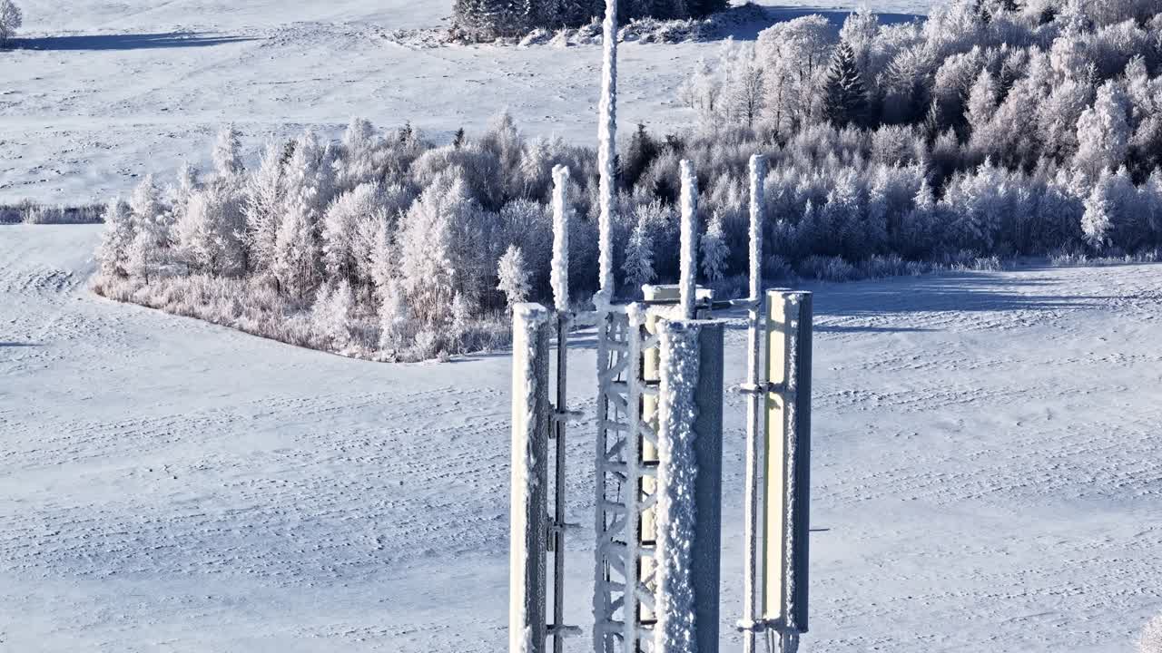Zmrzlý mobilní vysílač v zasněženém zimním lese, symbolizující komunikaci v drsných klimatických podmínkách.